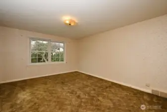 Primary bedroom (#3) in NW corner of house, newer windows, looking west to backyard. Hardwood floors underneath carpet.