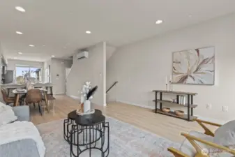 Bright and open living room with oversized windows, luxury vinyl plank flooring, and mini-split heating and A/C.