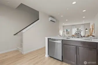 Contemporary kitchen with stainless steel appliances, quartz countertops, and full-height tile backsplash.