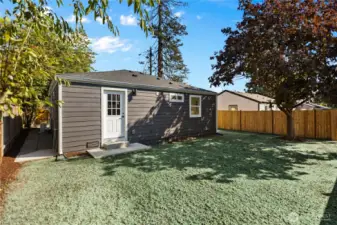 Backyard patio and newly hydroseeded grass with fenced yard