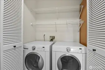 Utility closet with full size washer dryer.