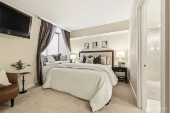 Primary bedroom with large windows and city outlook.