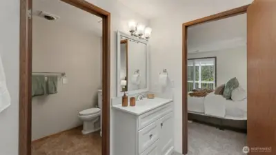 A practical and well-appointed ensuite featuring a private water closet and adjacent vanity space.