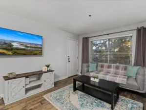 Sunny living room with access to private,  covered back balcony.