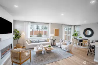 Bright and airy open-concept living and dining area featuring a sleek linear electric fireplace and large windows that flood the space with natural light.