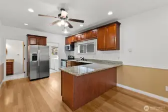 Living room and dining room facing into the remodeled kitchen that boasts slab granite countertops and eating bar.