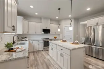 Upscale kitchen with slab counters and stainless steel appliances