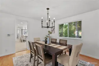 Formal dining room features fresh paint, new laminate flooring, updated light fixture and large window.