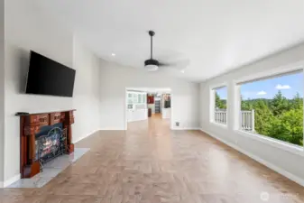 Living room with vaulted ceilings, huge windows, and two-way fireplace