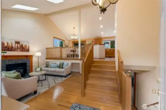 The entryway opens to a warm and welcoming floor plan with hardwood floors and vaulted ceilings. The multi-level layout offers a natural flow between the living room, dining area, and kitchen.