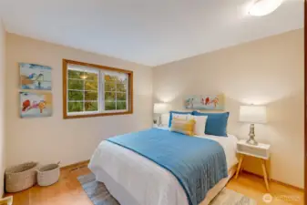 Cheerful and inviting bedroom featuring warm natural light, hardwood floors, and stylish décor. A versatile space that can easily serve as a secondary bedroom, guest space, or flex room.