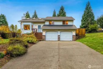 Beautifully maintained multi-level home with inviting curb appeal. Fresh landscaping, long driveway, and a welcoming entry framed by mature trees.