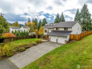 Wide-lot view highlighting the home’s spacious yard, mature greenery, and quiet neighborhood setting. A great blend of privacy and community feel.