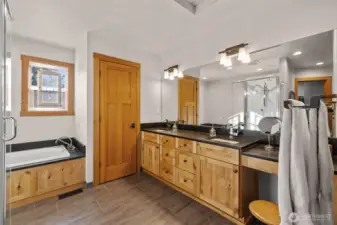 The primary suite features a luxurious five-piece bath with dual vanities, a deep soaking tub, separate glass-enclosed shower, and a private water closet for added comfort and privacy.