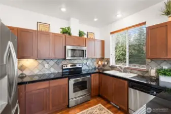 Cherry cabinets, granite counter and tile backsplash.