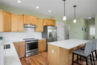 Just off of kitchen is the hallway to the additional bedroom, primary bedroom and primary bath.