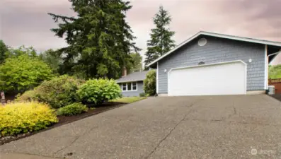 Mature landscaping, double car garage, RV or toy storage to right of the home.