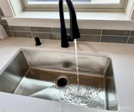 Oversized stainless sink with pull out faucet.