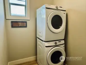 Laundry room offers full size stacking washer/dryer