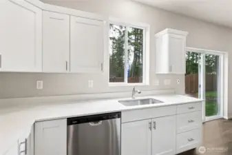 Kitchen sink area featuring white shaker cabinets, white quartz countertops, a stainless steel sink, dishwasher, window above the sink, and a sliding glass door to the backyard. Photos are representative only and may display different color packages and/or upgrades.