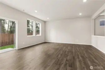 Bright great room and dining area featuring hardwood floors, neutral walls, recessed lighting, a sliding glass door to the backyard, and multiple windows for abundant natural light. Photos are representative only and may display different color packages and/or upgrades.