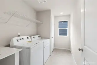Convenient upstairs laundry room with wire shelving,  neutral walls, and a window for some natural light. Photos are representative only and may display different color packages and/or upgrades.