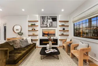 Main Floor Living with custom wood floating shelves & gas Fireplace. Custom Fabric blinds included!