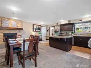 A view from your dining area to your newly updated propane fireplace and fresh kitchen.