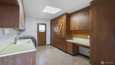 Expansive utility room with plenty of storage and work space, along with a sink.
