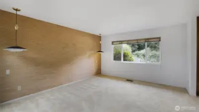 Another view of the primary bedroom showcasing stylish light fixtures and feature wall.