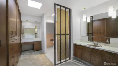 Another view of the primary bathroom that showcases the built-in closets and thoughtful privacy screen.