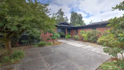 Tranquil front courtyard with mature landscaping.