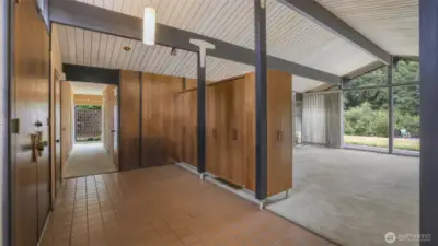 Double door entry to rustic floor tiling and practical storage.