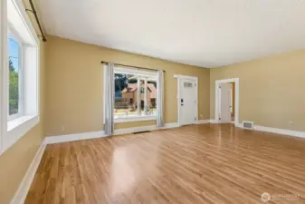 Unit A’s living room is a perfect blend of warmth and charm. The warm wood laminate flooring pairs beautifully with neutral tone walls and wide vintage white baseboards, creating an inviting and timeless atmosphere. With plenty of windows that bring in natural light, this room feels bright and airy. It also serves as the main entry to the home, making a great first impression as you step inside.