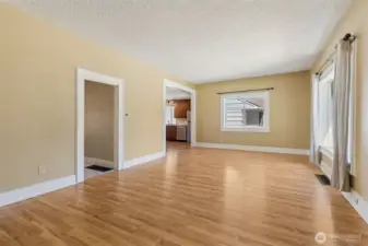 Unit A: Here is the living room with hallway to laundry room and full bath and den on the left and then the kitchen on the right.