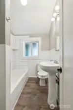 Unit A’s full main floor bathroom is all about timeless charm. The classic pillar sink adds elegance, while the tub with a tile shower surround creates a relaxing retreat. A window that opens with privacy glass allows natural light without compromising privacy. It’s a bathroom that feels welcoming and practical.