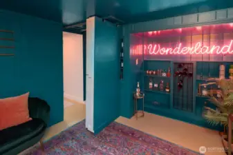 Hidden speakeasy-style room tucked behind custom built-ins—a perfect space for entertaining or relaxing in style.