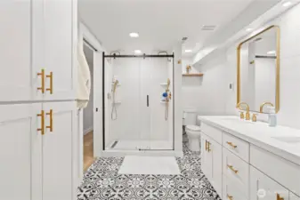 Another spa like bathroom for the lower level This is access from the hallway and the second primary walk in closet for privacy!  Whimsical floors, dual vanity and a double head shower!