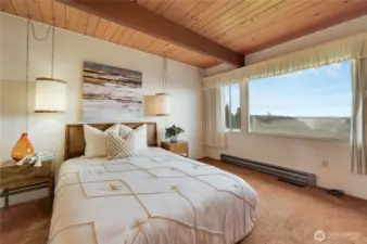 Inviting primary suite featuring exposed wood beams, soft natural light, and serene views. The attached primary bathroom completes the retreat, offering comfort and privacy in a peaceful, view-filled setting—your own calming escape at the end of the day.