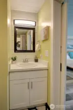 The primary bath also has stackable washer/dryer opposite the vanity.