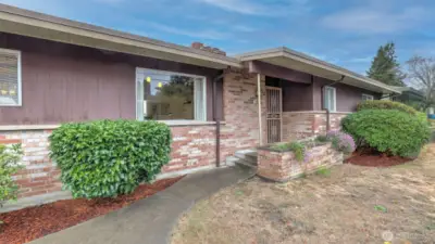 A welcoming front entry framed by mature landscaping and timeless brick accents.
