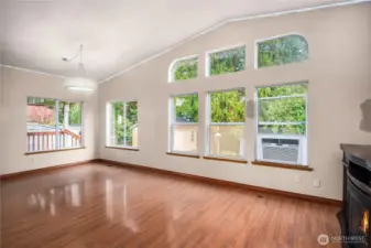 Light-filled great room/dining area with soaring ceilings and a dramatic window wall—perfect for everyday living and entertaining.