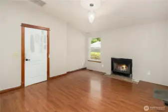 Bright and inviting! This living room features a teardrop chandelier and a true wood-burning fireplace for warmth and charm.