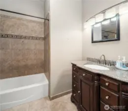 The second bathroom has custom tile work in the full sized shower/bathtub. A lovely vanity with brushed silver sink handles stores all your personal bathing needs.