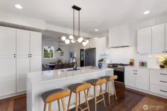 Modern kitchen has large island, ample storage, and pantry area