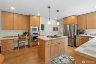 Let's check out the kitchen with new fridge, gas cooktop in the island, hardwoods, pendant lights and oven/microwave.