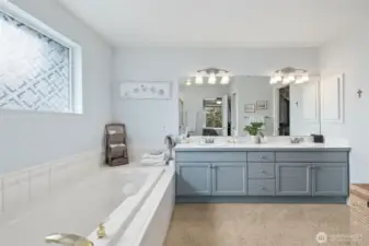 Primary Bathroom with luxurious soaking tub, updated lighting and vanity with double-sinks and loads of storage.