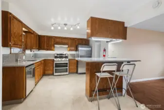 Well laid out kitchen with commercial fridge, tons of lighting and gas cooking.