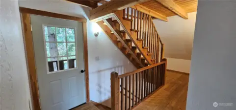 Wood crafted stairs, door to balcony on the front side.