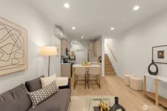 The open floor plan view shows off the beautiful flow from the living area to the kitchen, with sleek wood floors and designer finishes. This home is the epitome of functional style.